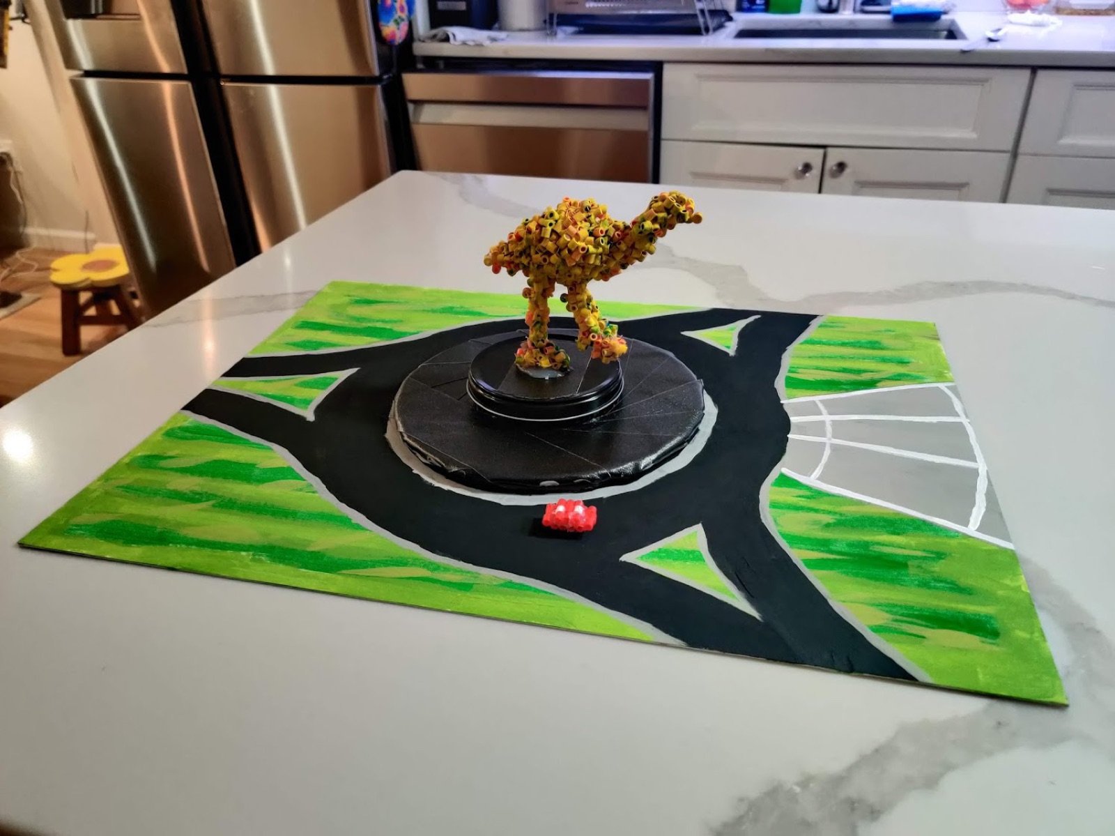 The finished Perler bead emu on a painted model of the roundabout